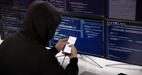 Suspicious Individual Wearing Balaclava Hacks Into Smartphone PIN © Andrey Popov