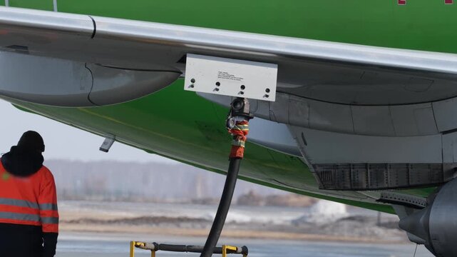 Airplane fueling. Airport technician man refueling aircraft. Terminal airline maintenance crew aviation kerosene fuel. Preparing for departure