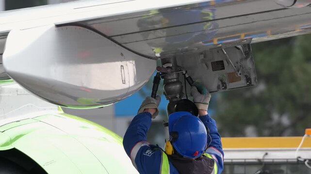 Airplane fueling. Airport technician man refueling aircraft. Terminal airline maintenance crew aviation kerosene fuel. Preparing for departure