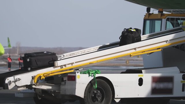 Airplane suitcases luggage baggage conveyor worker at airport terminal airline aircraft. Passengers boarding airplane.
