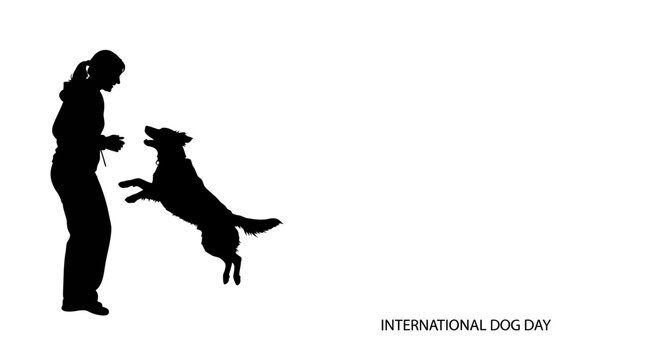 Silhouette of a woman training her playful dog for International Dog Day.