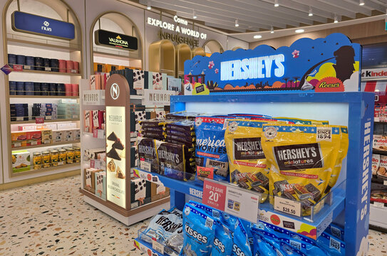 Changi, Singapore - Jan 14, 2026: A blue Hershey's branded retail display featuring Hershey's Miniatures, Kisses, and Reese's products at an airport confectionery store.