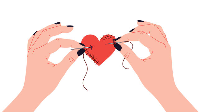 Two female hands with black nail polish carefully sewing a broken red heart back together representing emotional healing.