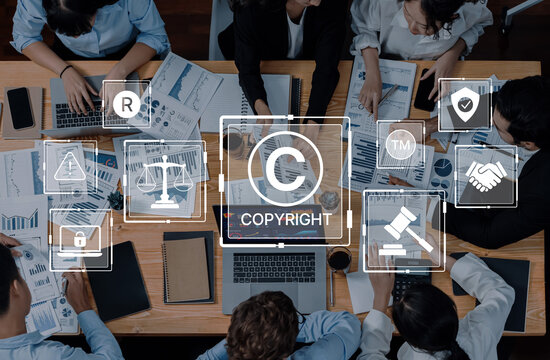 A diverse business team discusses copyright and trademark topics while analyzing data in a modern office setting, combining technology with legal concepts. Trope