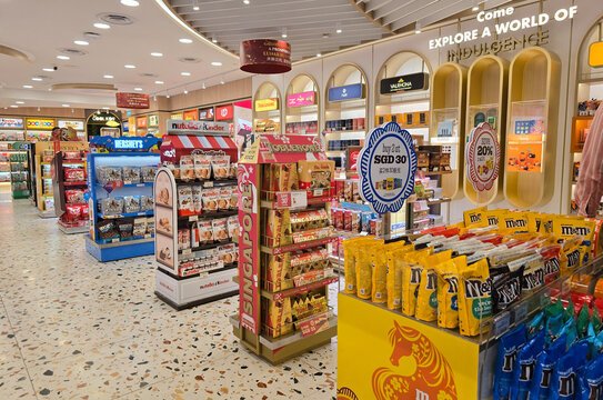Changi, Singapore - Jan 14, 2026: Colorful retail displays of international chocolate brands including MM's, Toblerone, Nutella, and Hershey's at a duty-free store in the airport terminal.