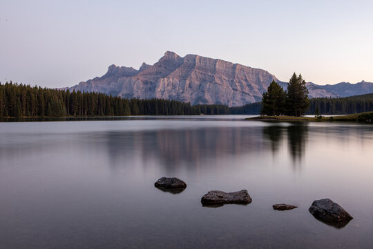 Tranquil Mountain Lake at Dusk With Forested Shoreline and Soft
