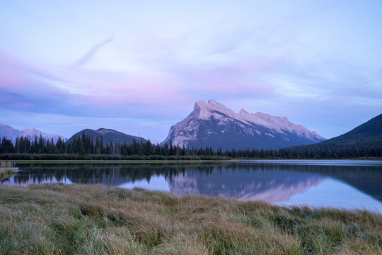 Serene Mountain Lake With Pine Forest and Rugged Peaks Under Sof