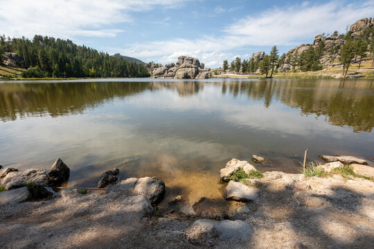 Tranquil Mountain Lake With Rocky Shoreline, Pine Forest and Ref