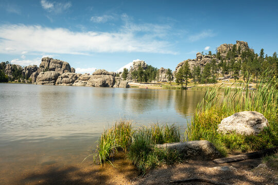 Serene Rocky Lake Landscape With Pine Trees, Granite Outcrops an