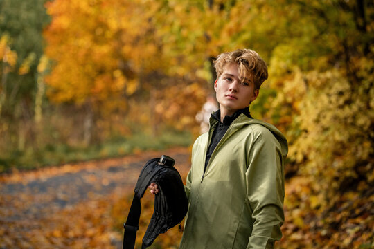 athlete rests and drinks from a hydration pack while jogging in park.