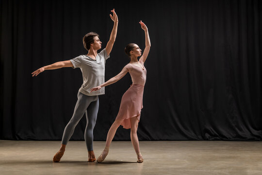 Ballerina and ballet dancer performing duet on stage.