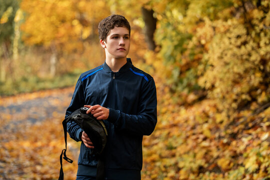 athlete rests and drinks from  hydration pack while jogging in park.