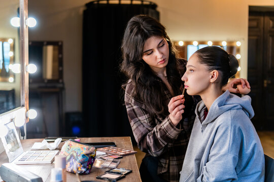 professional specialist works with a model in a studio with a mirror.