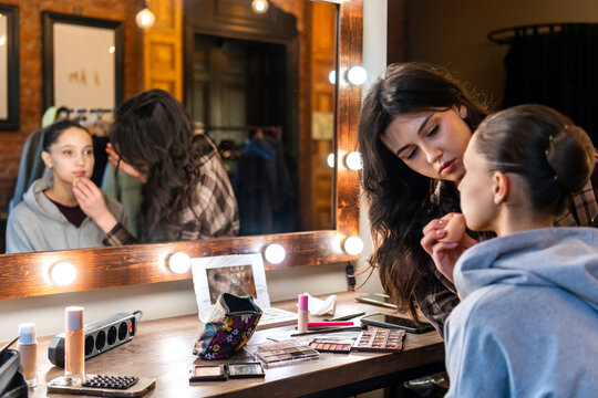 Makeup artist preparing ballerina for stage