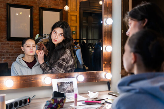 Makeup artist applying foundation on ballerina