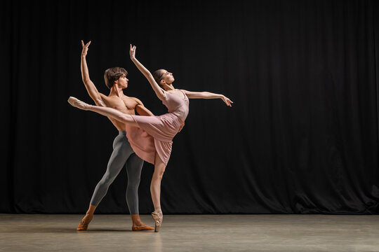 Ballerina and male ballet dancer performing on theater stage.