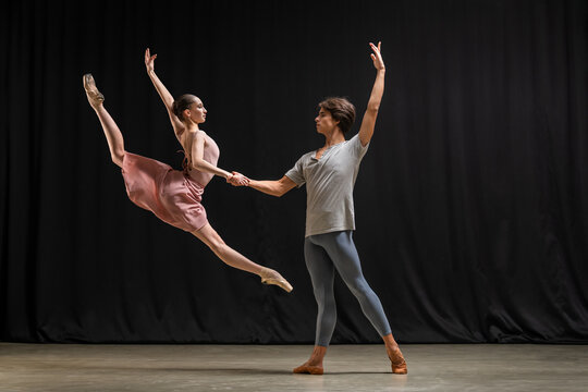 Professional Ballerina and ballet dancer performing duet on stage.