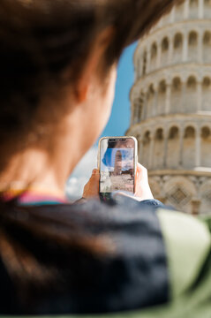 A person taking a photo of the leaning tower of Pisa
