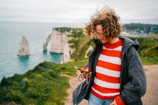 Woman checking a mobile phone on a cloudy day