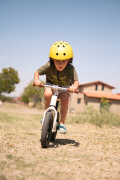 Little Boy Racing Balance Bike Outdoors in Sunny Desert Landscape