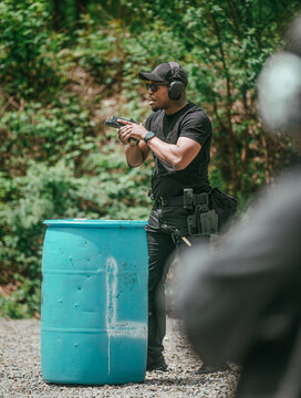 Man aiming a handgun during outdoor firearms training