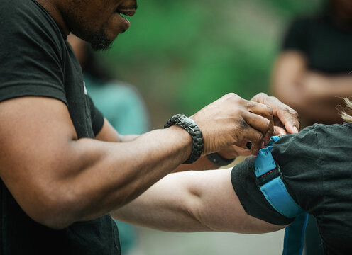 A man demonstrates how to apply a tourniquet