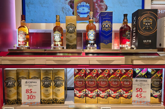 Singapore, Singapore - Jan 14, 2026: A retail display of Chivas Regal 12, 15, 18, and Ultis blended scotch whisky bottles with promotional pricing at a duty-free shop in Changi International Airport.
