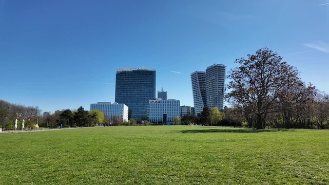 Prague, Czech Republic - April 07, 2026 - Pankrac. Modern city park with green lawn and contemporary skyscrapers under blue sky