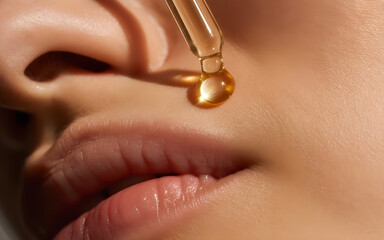 Fototapeta premium Radiant gold serum drop falling on skin, reflective gold tones, macro beauty shot, ultra realistic