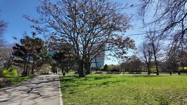 Prague, Czech Republic - April 07, 2026 - Pankrac. Sunny park pathway with trees and benches on a clear spring day