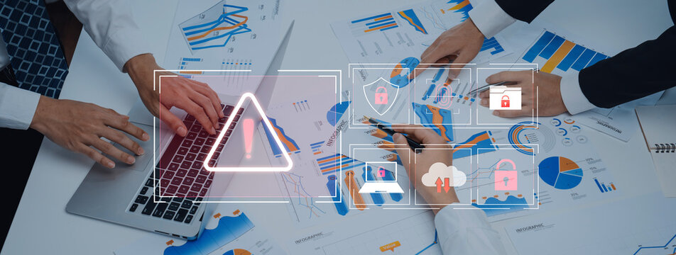 A business team collaborates around a table, analyzing data and charts while highlighting cybersecurity risks, emphasizing proactive management and secure strategies. Trope
