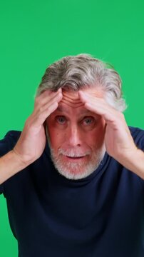 Senior man being surprised on green screen background