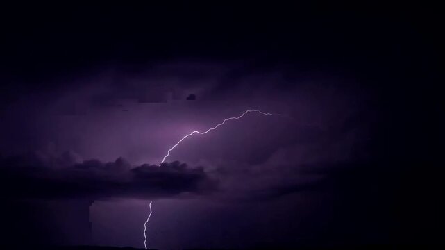 Dramatic lightning illuminating stormy clouds over a dark landscape at night