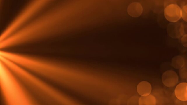 An abstract image featuring a warm orange glow and blurred bokeh effects.