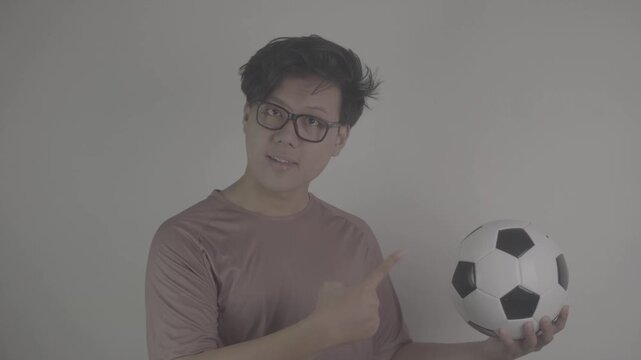 Southeast Asian people point to the soccer ball they are carrying, while occasionally looking at the camera S-Log3, S-Gamut3.Cine