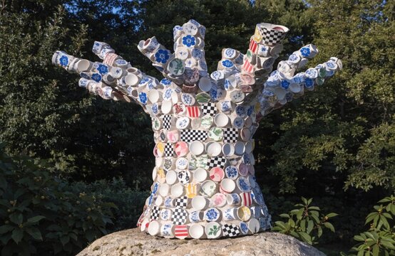 A tree whose bark is made from mosaic fragments of old patterned ceramic cups. The trunk looks like an artifact. Surrealism.