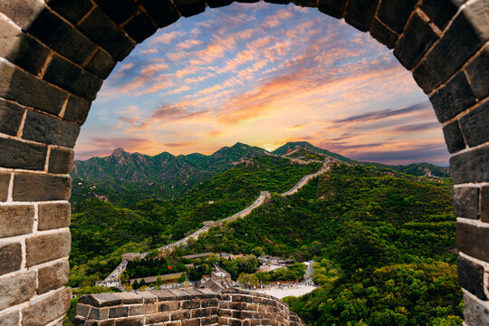 Arched stone window framing The Great Wall and mountains at sunset view, travel Beijing China