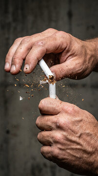 Hands breaking a cigarette with tobacco scattering, against a textured dark background, symbolizing quitting smoking and health awareness, broken