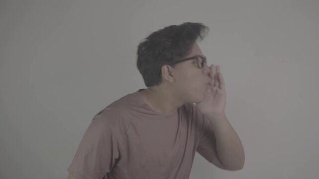 Southeast Asian person wearing brown jersey, with his palms open and his hands cupped around his mouth, shouts loudly, side view S-Log3, S-Gamut3.Cine