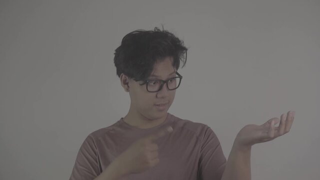 Southeast Asian person wearing brown jersey, points to one empty hand, used to indicate an item S-Log3, S-Gamut3.Cine
