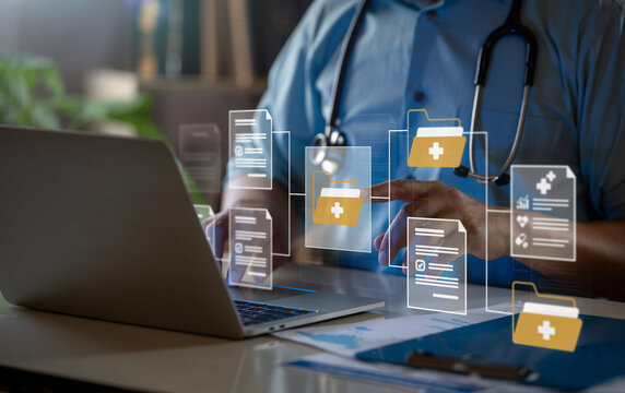 Doctor Managing Digital Medical Records on Laptop