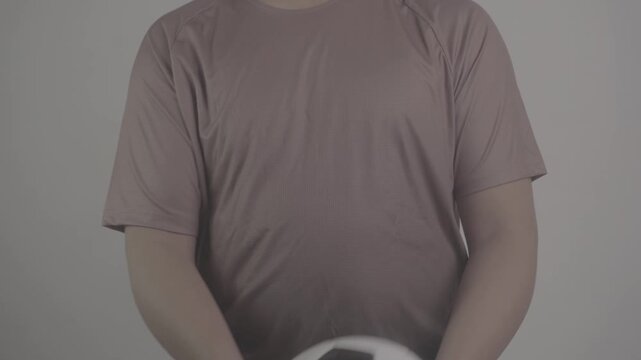 close up shot of a person wearing a brown jersey, slowly throwing a soccer ball upwards S-Log3, S-Gamut3.Cine