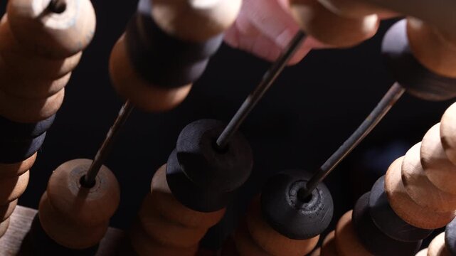 Macro view of vintage wooden abacus beads on rods representing counting calculation education finance and business accounting concept