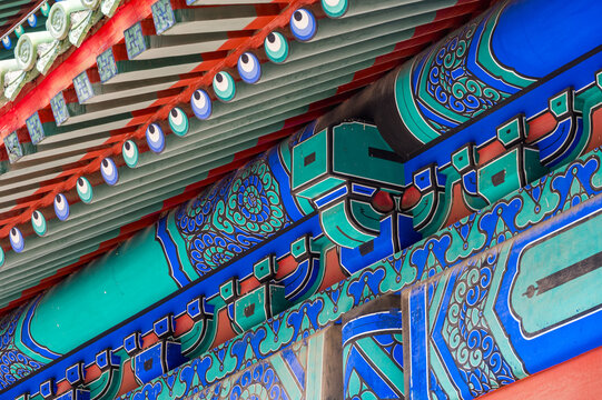 An intricate close-up reveals the colorful painted patterns and traditional wooden brackets on an imperial building at Beijing's Temple of Heaven.