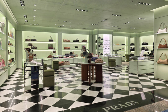 Changi, Singapore - Jan 14, 2026: Elegant interior of a Prada retail store featuring checkered marble floors and displays of designer handbags and accessories at Changi International Airport.