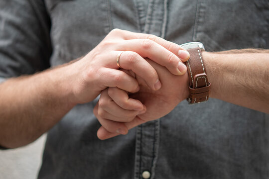 Man with wristwatch looks at the time