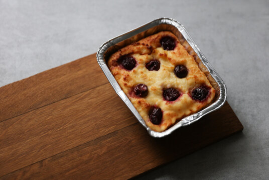Cottage cheese casserole with cherries on concrete background
