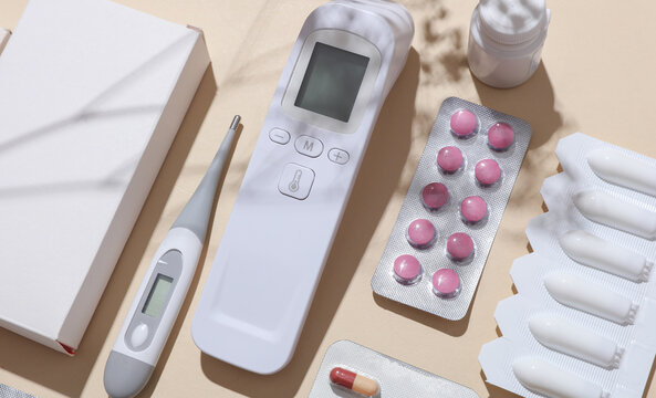 Mockup of medicines with boxes, thermometer on beige background with shadow. Flat lay. Top view