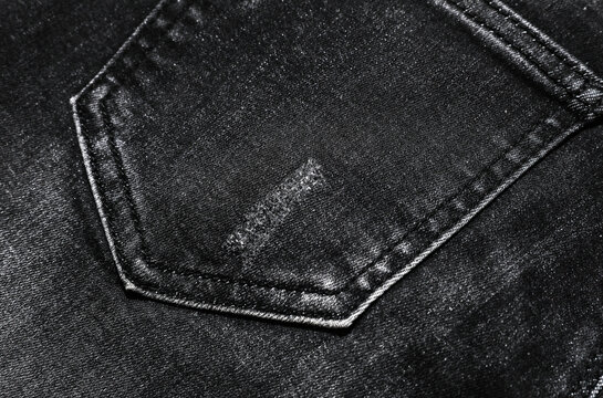 Close-up of the back pocket of black jeans