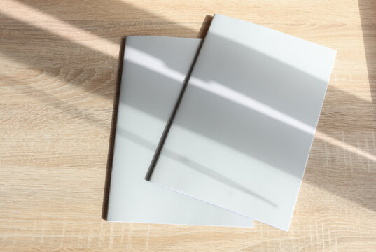 Corporate business books or magazines on table with shadow. Mockup for design